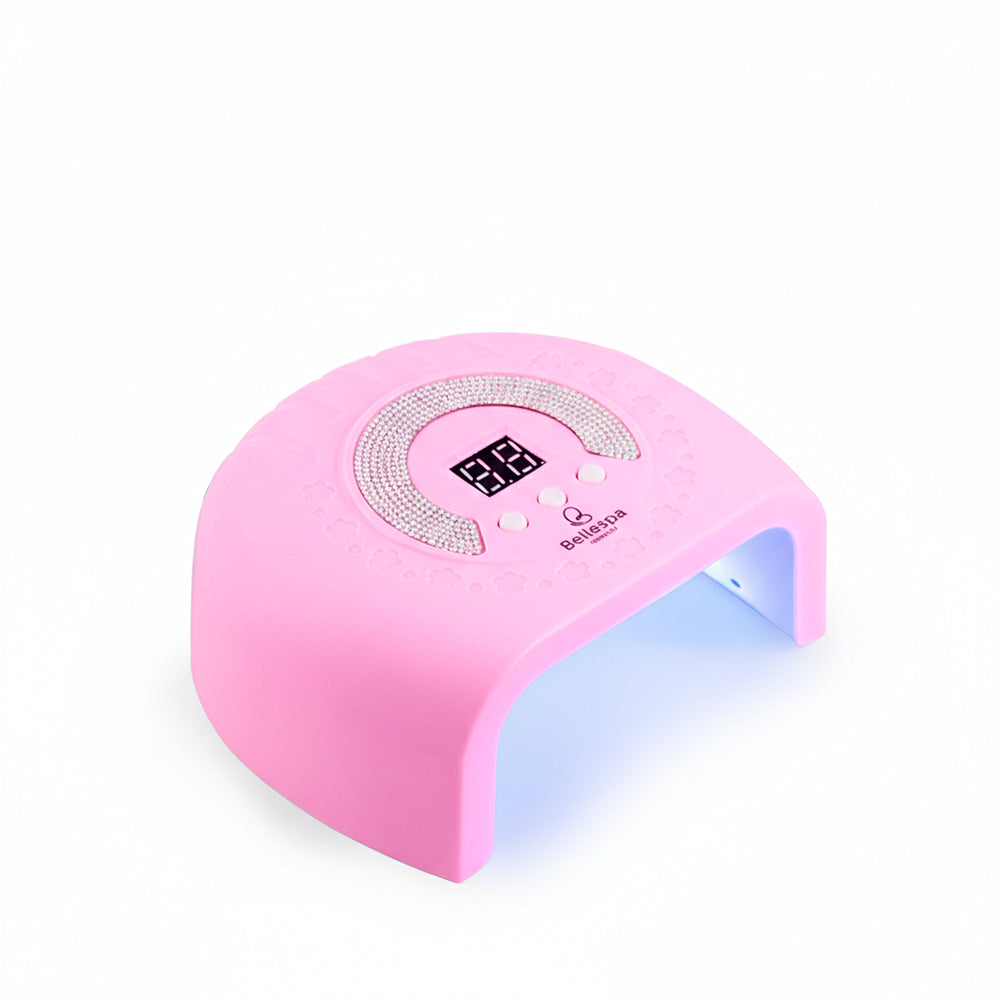 Lámpara UV LED para Uñas con Pedrería Bellespa Cosmetics color rosa suave con luz LED activa y pantalla digital, vista frontal sobre fondo blanco