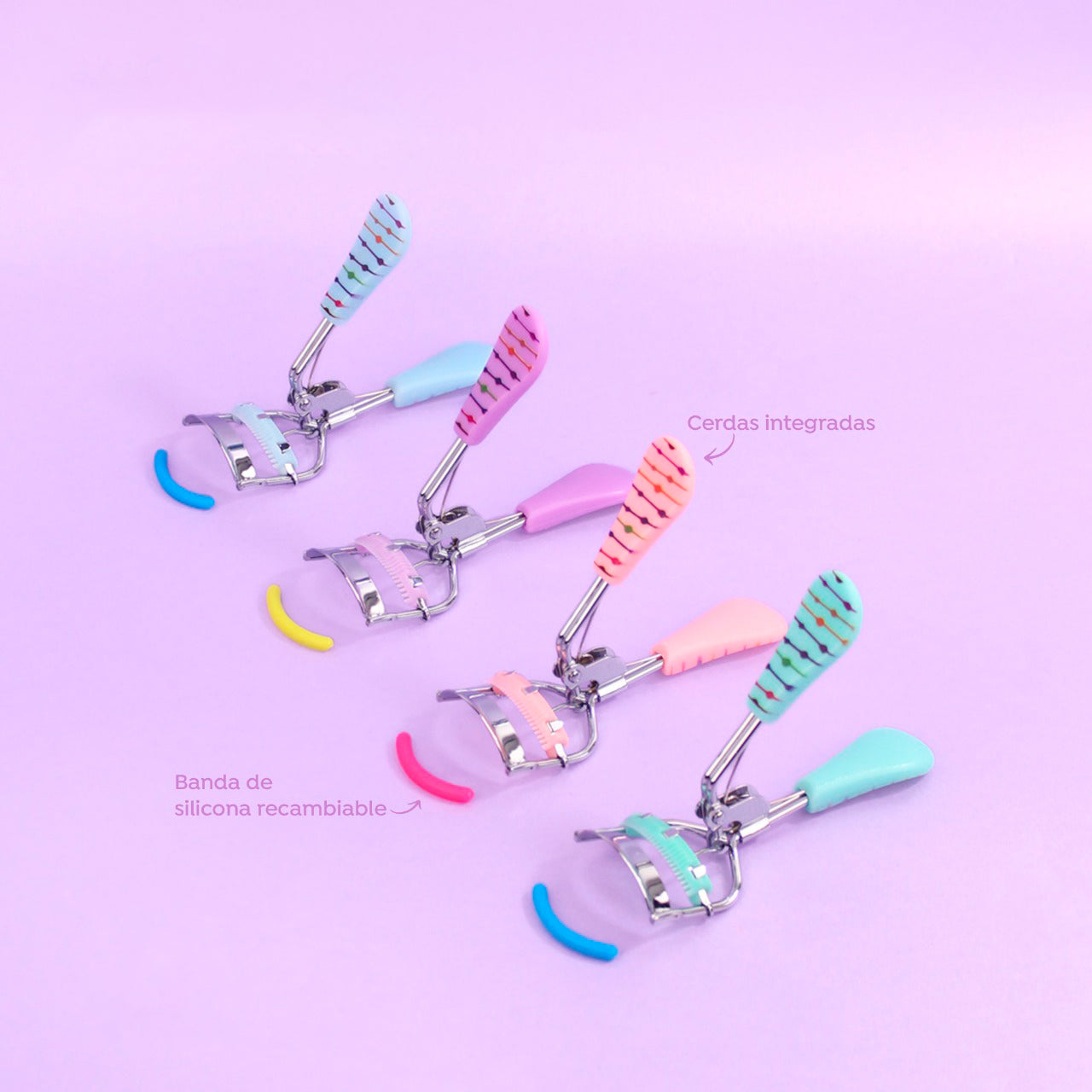 Rizador de pestañas Presión Touch Dot Print con mango bicolor estampado de puntos en colores celeste, lila, rosa coral y menta, cerdas integradas y banda de silicona recambiable sobre fondo lila