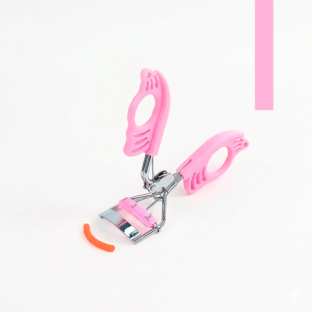 Rizador de pestañas Mariposa Curl Bellespa con mango calado rosa suave y banda de silicona recambiable sobre fondo rosa