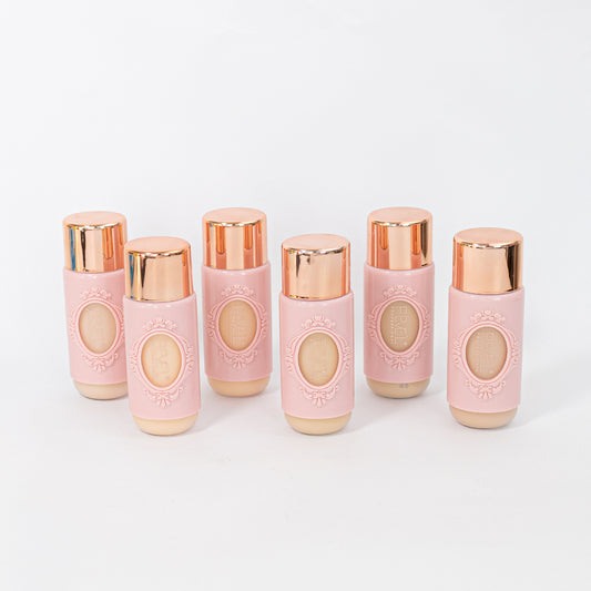 Base líquida crema en frasco rosa con tapa dorada en 6 tonos sobre fondo blanco — Reve'l Professional 43 ml