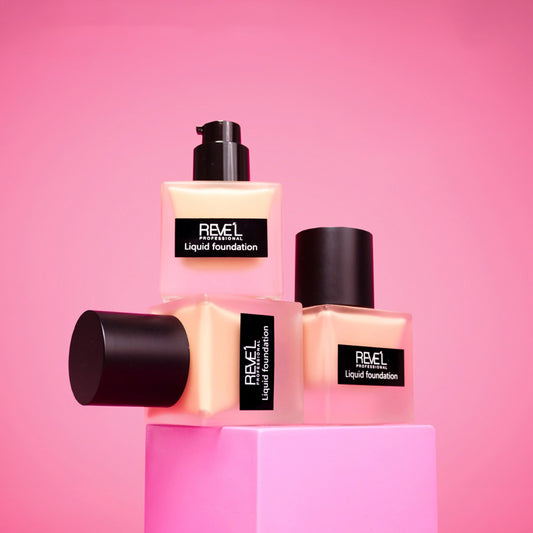 Base líquida Liquid Foundation 24H con dispensador tipo bomba y tapa negra sobre fondo rosa — Reve'l Professional