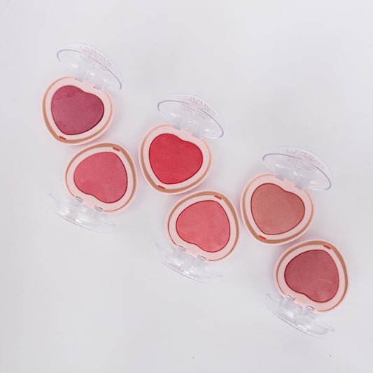 Seis tonos de rubor baked corazón Charm Make Me Bellespa Cosmetics abiertos mostrando variantes desde rosa intenso hasta nude rosado