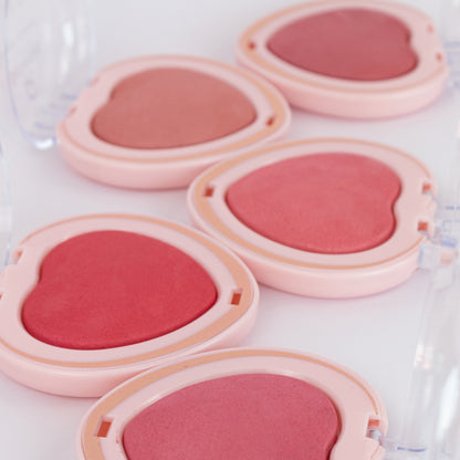 Detalle de rubor baked corazón Charm Make Me Bellespa Cosmetics mostrando textura y tonos desde nude rosado hasta rosa intenso