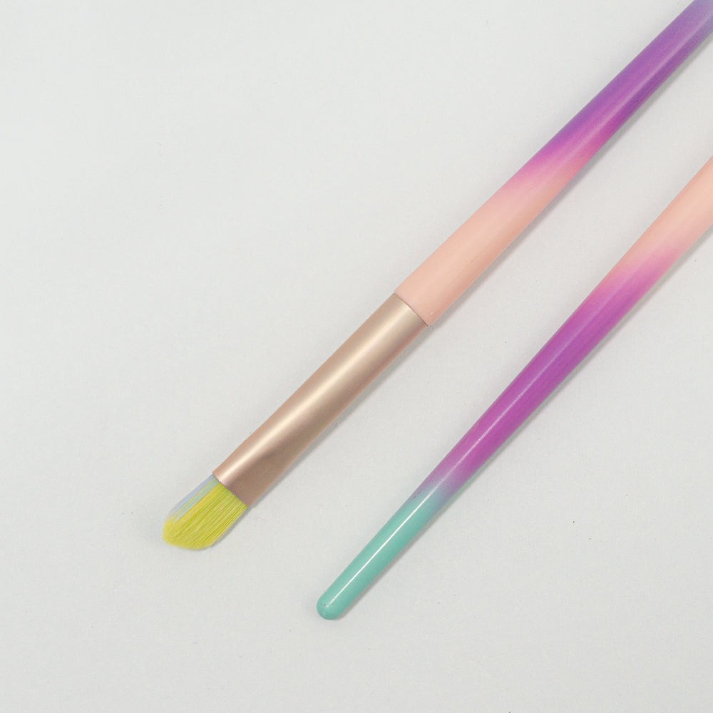 Detalle de punta plana de brocha de delineado cerdas amarillas degradé Malif Beauty con ferrule rose gold y mango rosa morado y menta sobre fondo blanco