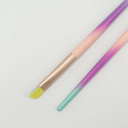 Detalle de punta plana de brocha de delineado cerdas amarillas degradé Malif Beauty con ferrule rose gold y mango rosa morado y menta sobre fondo blanco