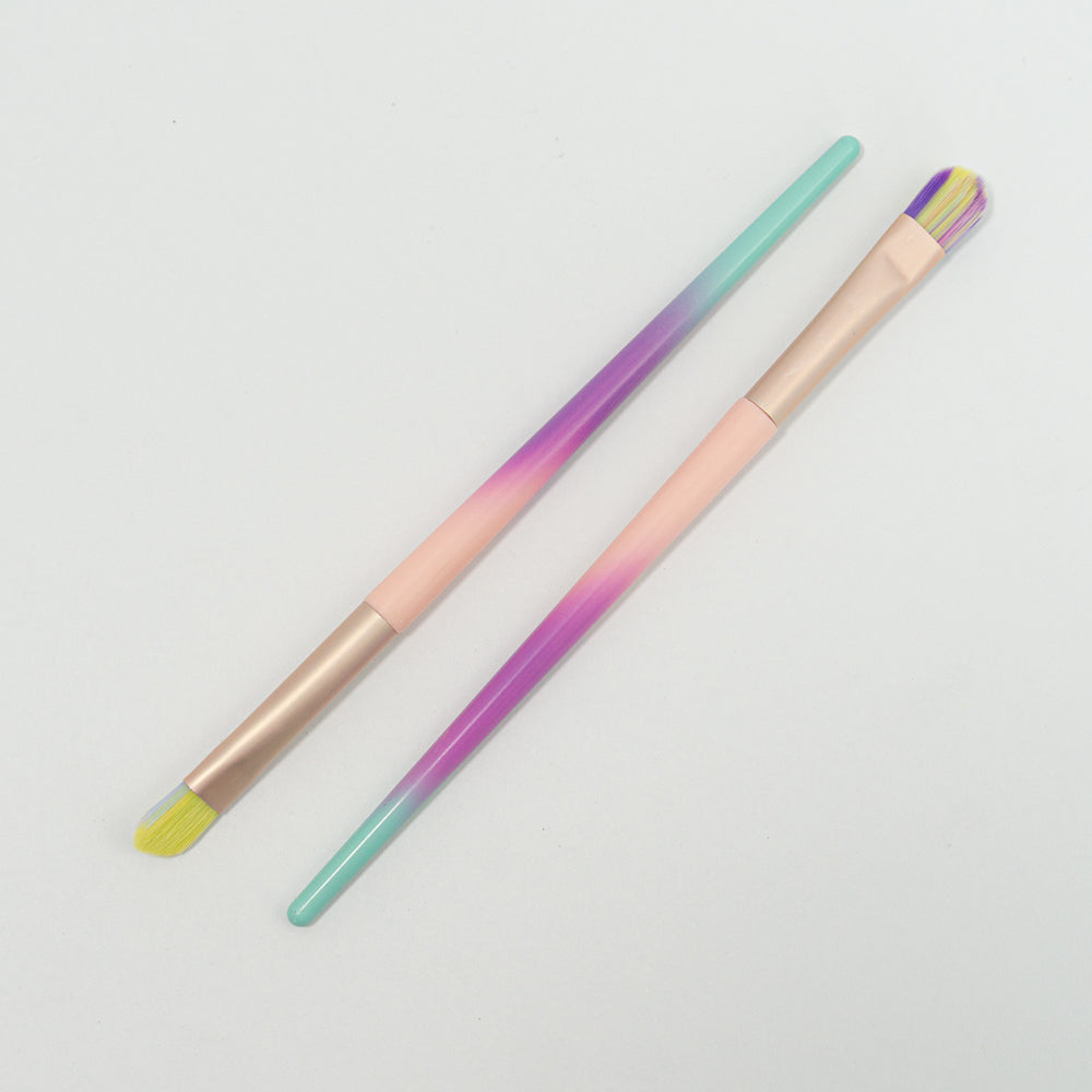 Brocha de delineado cerdas multicolor degradé en punta angular y plana cuadrada con mango menta morado y rosa y ferrule rose gold sobre fondo blanco
