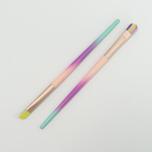 Brocha de delineado cerdas multicolor degradé en punta angular y plana cuadrada con mango menta morado y rosa y ferrule rose gold sobre fondo blanco