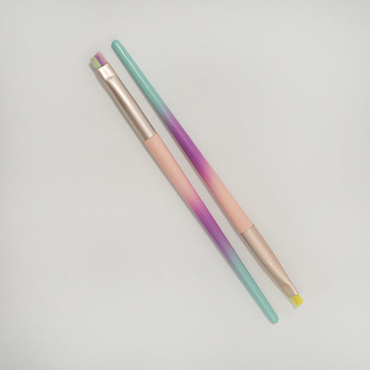 Brocha de delineado punta redonda y abanico cerdas multicolor degradé con mango menta morado y rosa y ferrule rose gold sobre fondo blanco