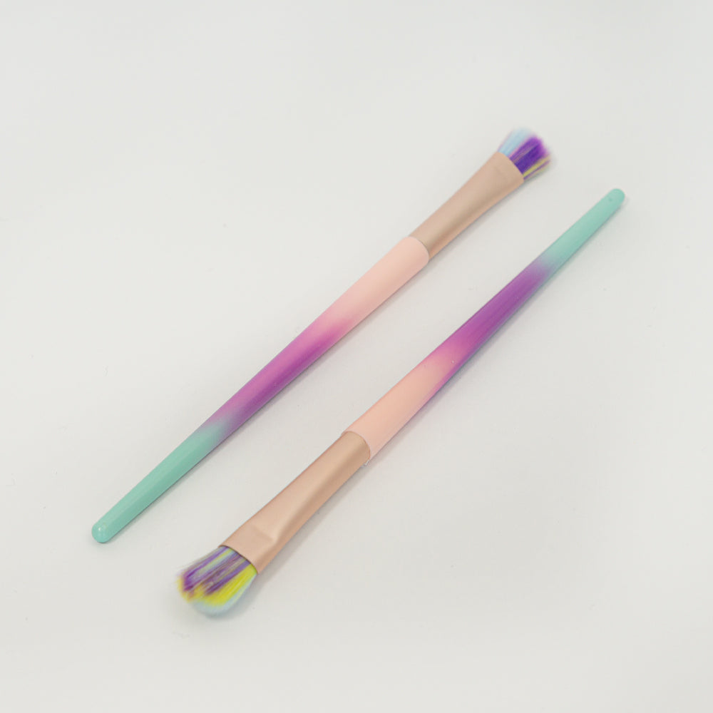 Brocha focalizada para sombras de ojos con mango degradado en rosa, morado y verde menta, sobre fondo blanco