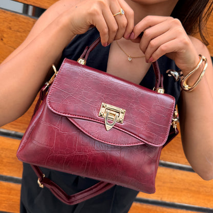 Cartera Aurora Elegance en variantes de color vino, marrón oscuro, negro y beige con textura cocodrilo y cierre dorado