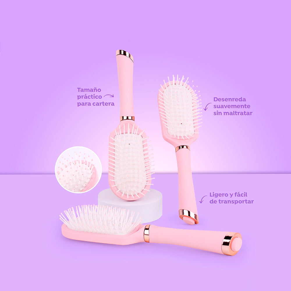 Cepillo compacto plegable Mini Care Brush rosa pastel con cerdas flexibles y detalles rose gold tamaño cartera para desenredar sin maltratar sobre fondo lila