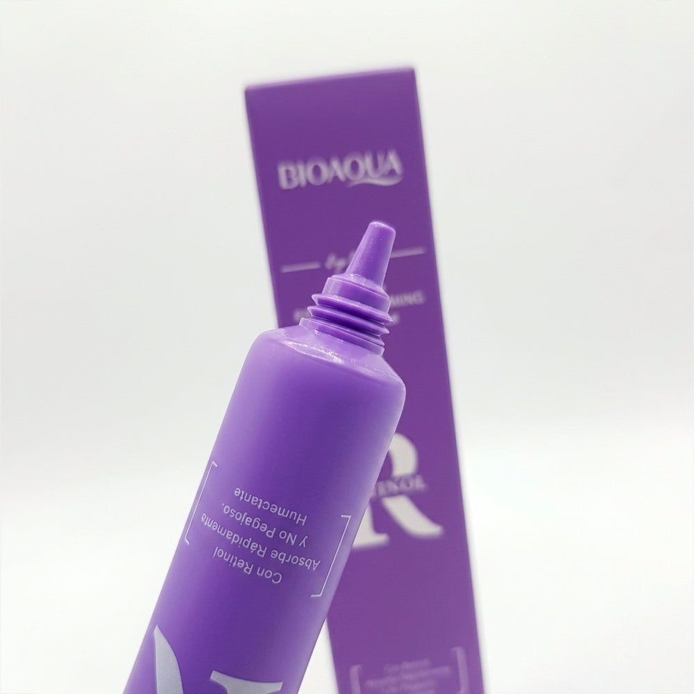 Detalle de punta aplicadora del Contorno de Ojos Retinol Anti-Aging Firming Eye Cream Bioaqua, tubo morado con caja al fondo