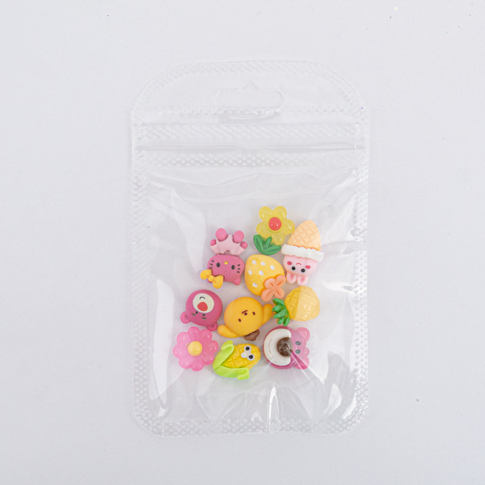 Dijes para uñas Nail Art de frutas y personajes kawaii en resina en bolsa transparente sobre fondo blanco