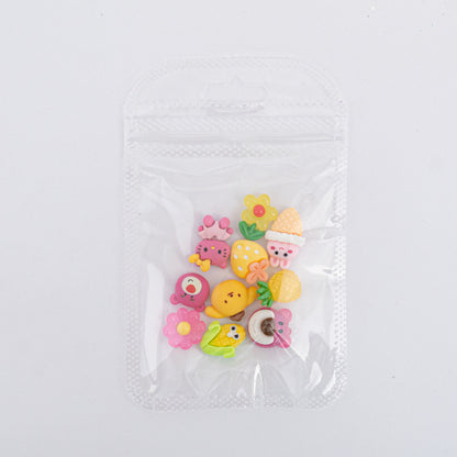 Dijes para uñas Nail Art de frutas y personajes kawaii en resina en bolsa transparente sobre fondo blanco