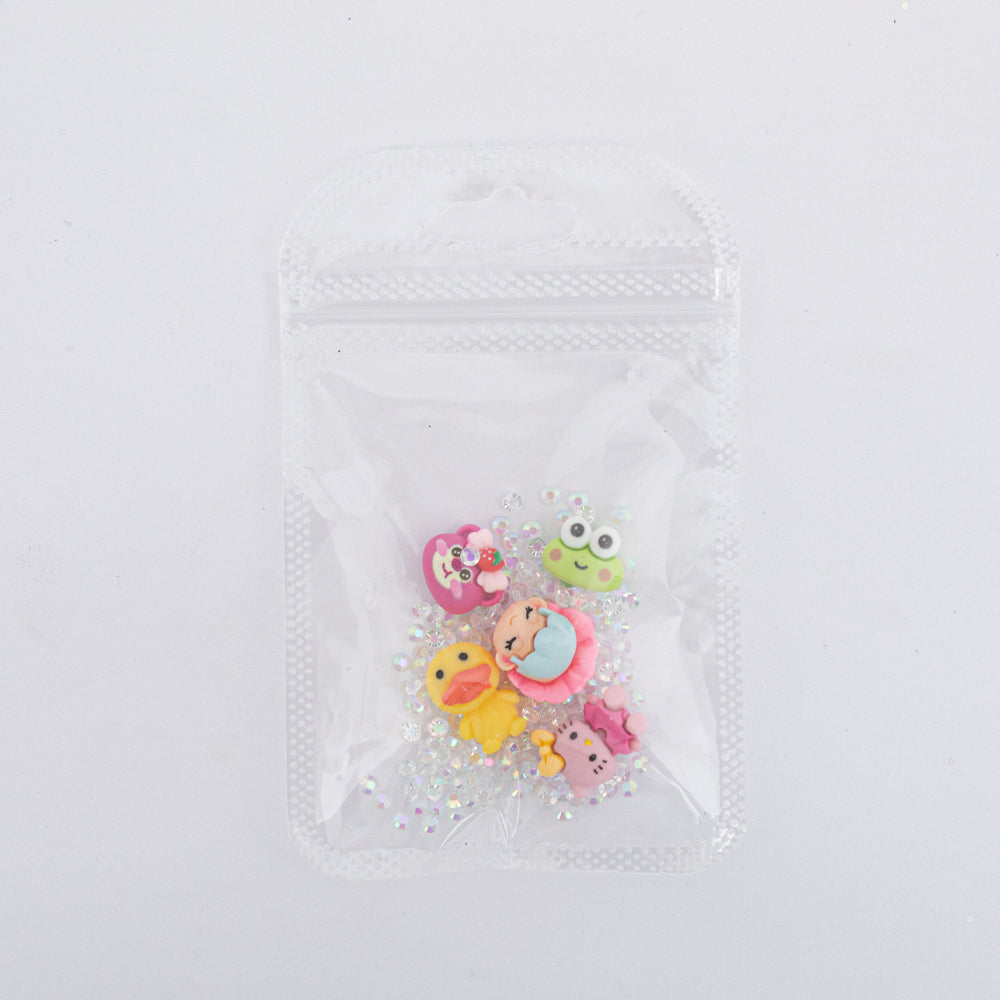 Dijes para uñas Nail Art de personajes kawaii con strass en bolsa transparente sobre fondo blanco