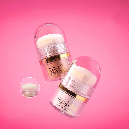 Reve'l Highlighting Face & Body Shining en tarro transparente con borla aplicadora y tapa domo en tonos cobre y rosa sobre fondo rosa