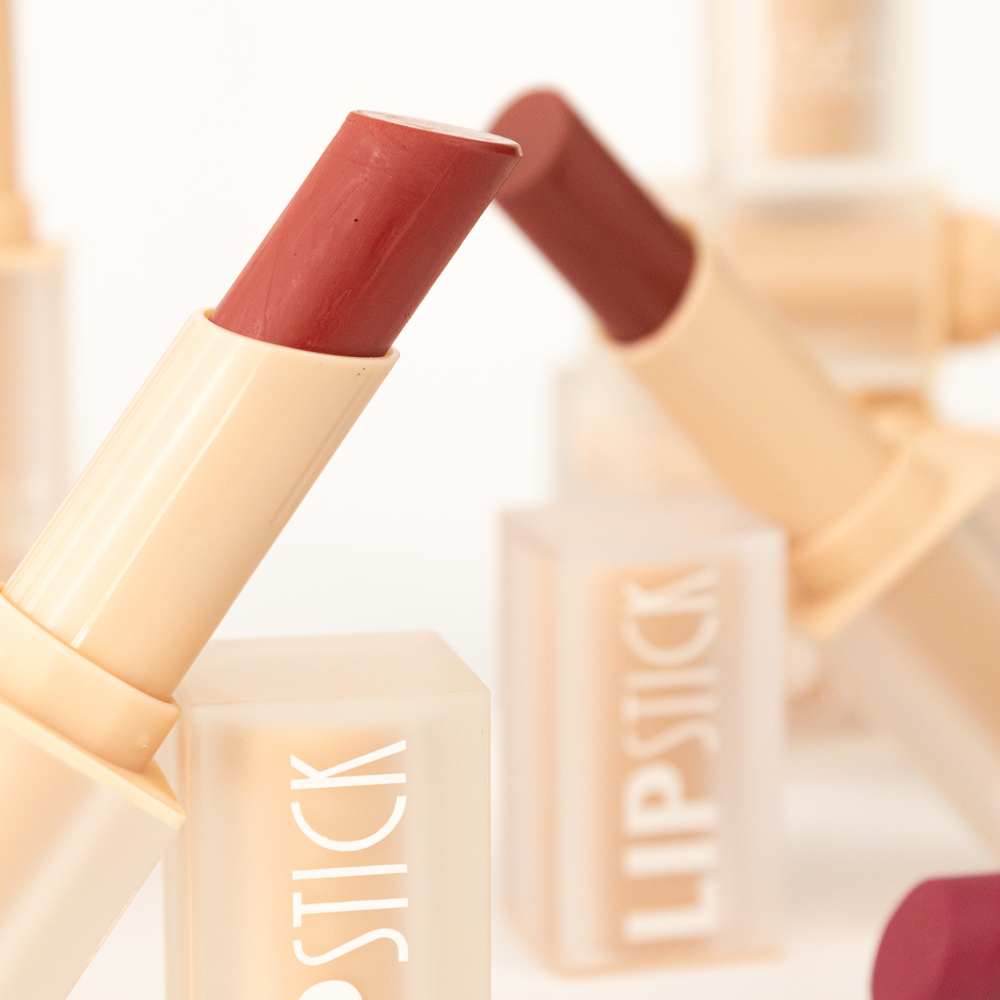 Labial en barra tono nude y vino ultra matte Reve'l Professional con empaque traslúcido beige, vista de cerca mostrando textura y color