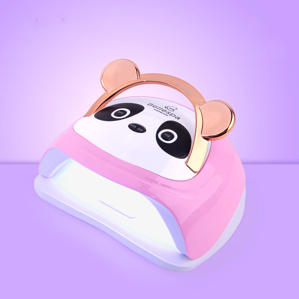 Lámpara UV LED para uñas Bellespa Cosmetics color rosa con diseño de panda, orejas y asa en rose gold, panel frontal con cara de panda y base blanca con LEDs activos, sobre fondo lila degradado