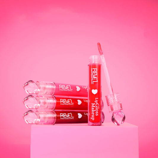 Lip gloss Reve'l Professional LipGloss Makeup con tapa diamante traslúcida, tonos desde rosa suave hasta rojo vibrante, aplicador y empaque sobre fondo rosa