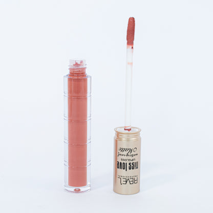 Lip gloss matte waterproof Reve'l Miss Love tono nude coral con aplicador aterciopelado y tapa dorada champagne, sobre fondo blanco