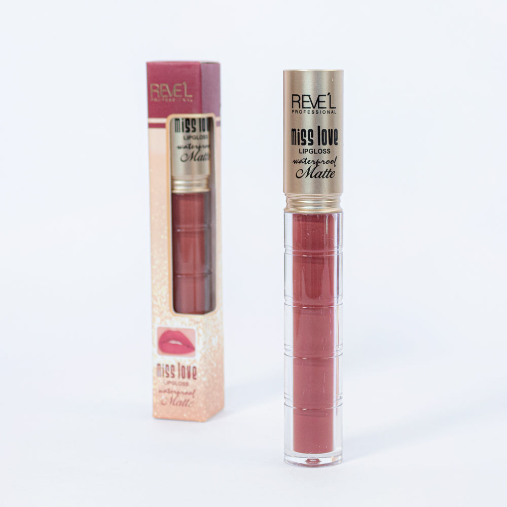 Lip gloss matte waterproof Reve'l Professional Miss Love en tono nude rosado con tapa dorada champagne y caja glitter rosada, sobre fondo blanco