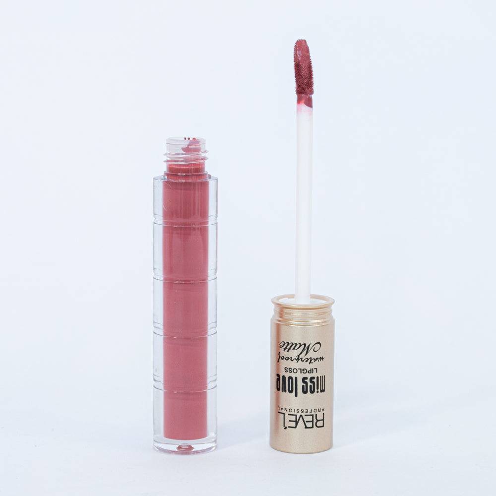 Lip gloss matte waterproof Reve'l Miss Love tono rosa palo con aplicador aterciopelado y tapa dorada champagne, sobre fondo blanco