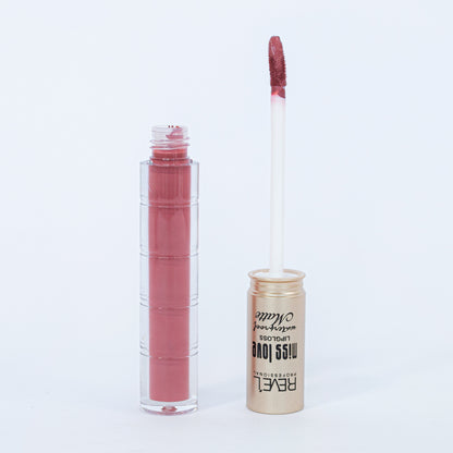 Lip gloss matte waterproof Reve'l Miss Love tono rosa palo con aplicador aterciopelado y tapa dorada champagne, sobre fondo blanco