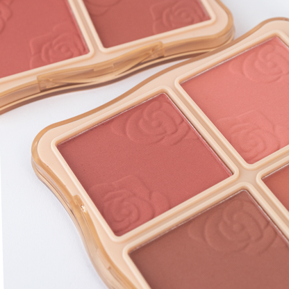 Detalle de textura de la paleta de rubor Hello Perfect Blusher Reve'l con tonos rosados y marrón en relieve de rosas sobre compacto dorado