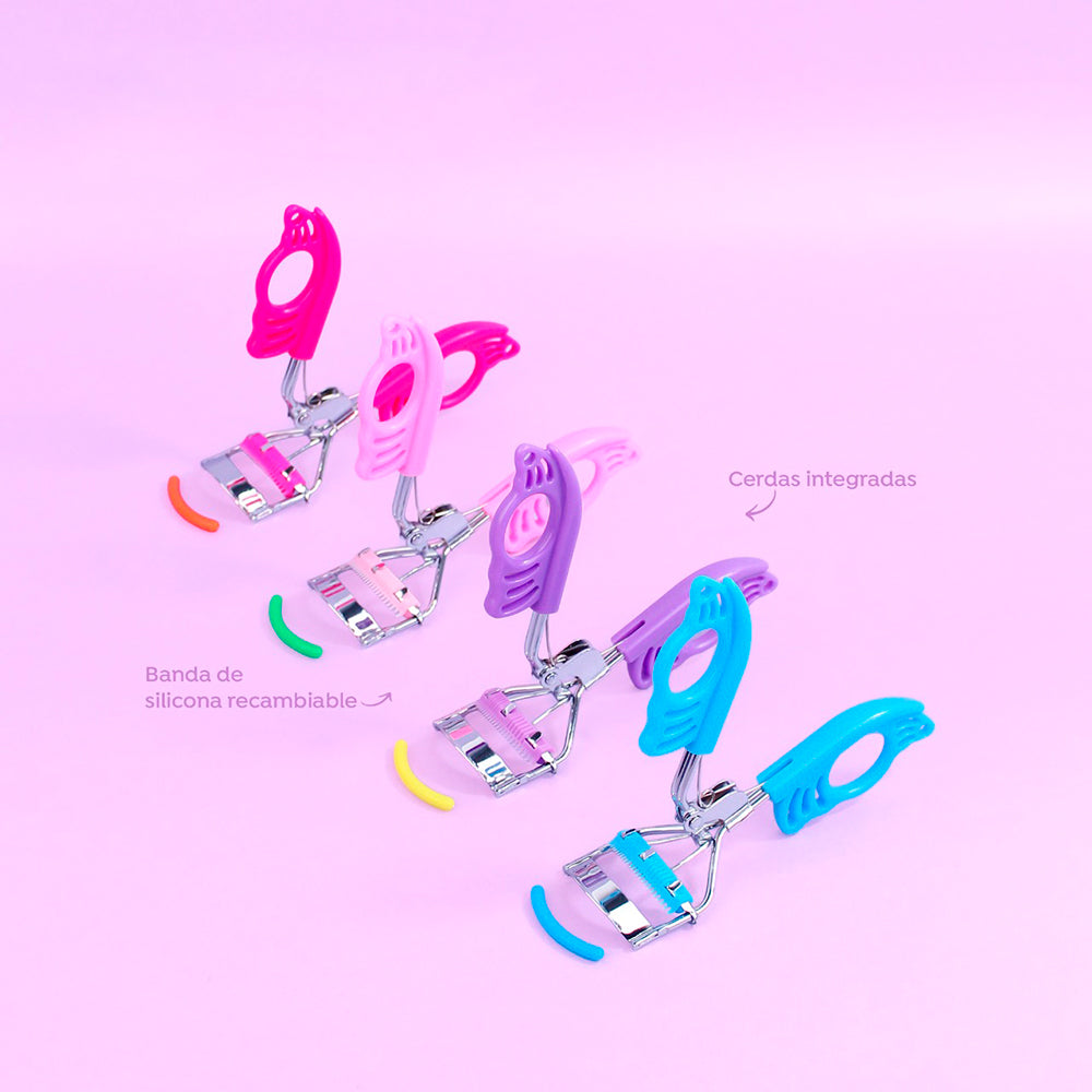 Rizador de pestañas Mariposa Curl Bellespa con mango calado diseño mariposa en colores fucsia, rosa, morado y celeste, cerdas integradas y banda de silicona recambiable sobre fondo rosa
