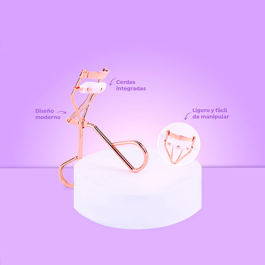Rizador de pestañas Rose Gold Glam con cerdas integradas, diseño moderno y ligero en color oro rosado sobre fondo lila