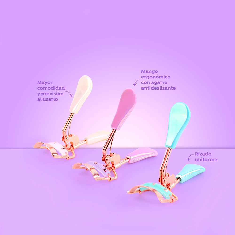 Rizador de pestañas Soft Grip Curl con mango ergonómico antideslizante en colores blanco, rosa y verde menta sobre fondo lila