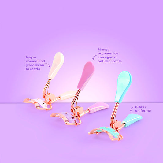 Rizador de pestañas Soft Grip Curl con mango ergonómico antideslizante en colores blanco, rosa y verde menta sobre fondo lila