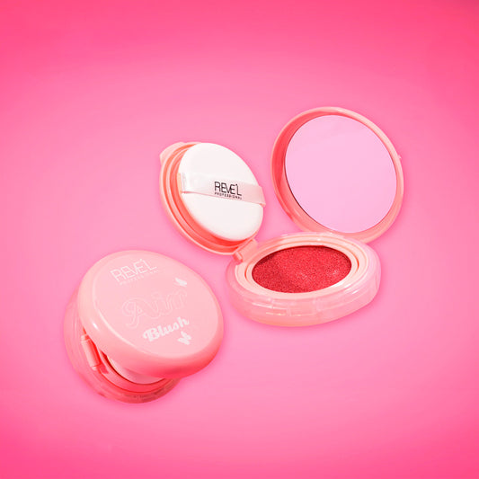 Rubor cushion Air Blush Reve'l Professional abierto mostrando rubor en crema rojo rosado con aplicador puff y espejo integrado sobre fondo fucsia