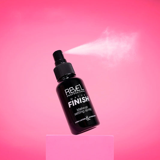 Sellador de maquillaje Matte Finish Long-Lasting y Refreshing Reve'l Professional en envase negro con spray activo sobre fondo fucsia