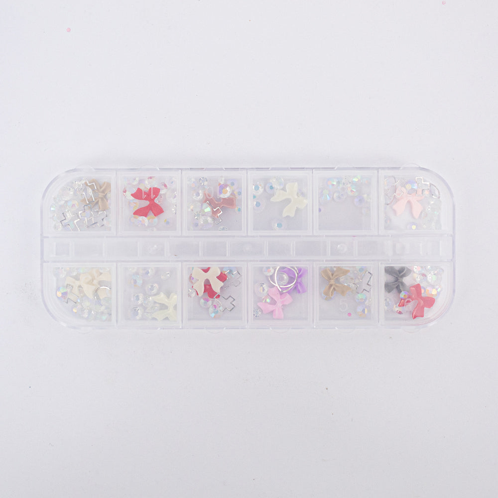 Set adornos para uñas nail art moños resina multicolor y strass AB en estuche 12 compartimentos sobre fondo blanco