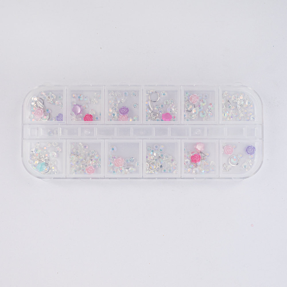 Set adornos para uñas nail art rosas resina y strass AB cristal en estuche 12 compartimentos sobre fondo blanco