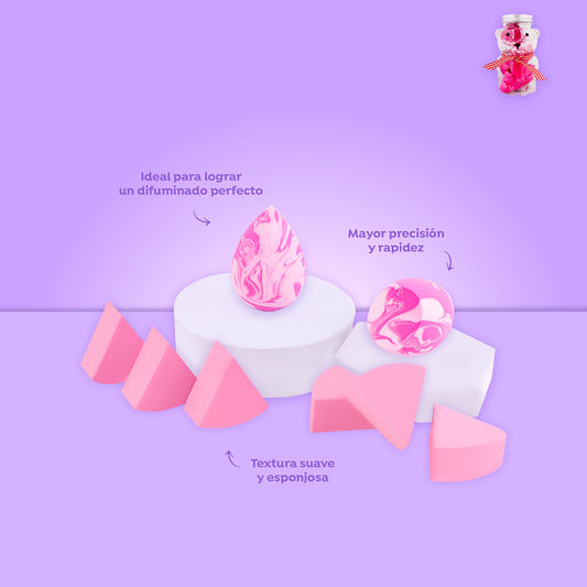 Set de maquillaje con 2 blenders marmoleados rosa y 6 puffs triangulares sobre fondo lila, incluye estuche en forma de osito