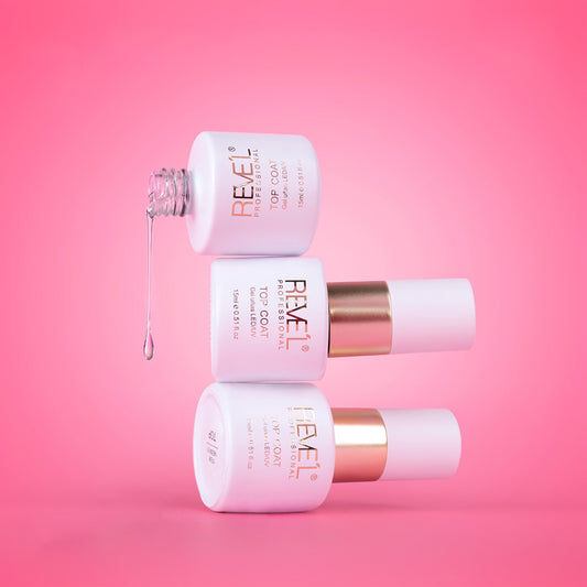 Top coat gel uñas LED UV acabado brillante 15ml Revel Professional en frasco blanco con banda dorada y fórmula transparente sobre fondo rosado